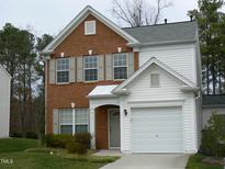 Two-story brick and vinyl home with a two-car garage and landscaped lawn at 142 Brentfield Loop, Morrisville, NC 27560