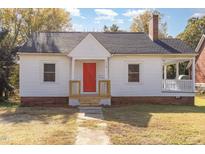 Charming white house with red door, brick base, and small front porch at 619 N Mebane St, Burlington, NC 27217