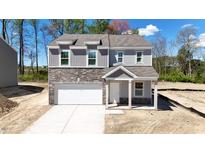 Two-story house with gray siding, stone accents, and a two-car garage at 281 Logan Creek Dr, Zebulon, NC 27597