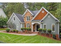 Two-story house with gray siding, stone accents, and a landscaped yard at 2725 Penfold Ln, Wake Forest, NC 27587