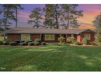 Brick ranch house with a well-maintained lawn at 739 Silk Hope Lindley Mill Rd, Siler City, NC 27344