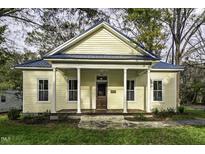 Charming yellow house with blue metal roof, porch, and stone walkway at 915 S 3Rd St, Sanford, NC 27330
