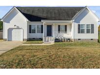 White house with gray shutters, attached garage, and a small front porch at 96 Abram Ct, Broadway, NC 27505