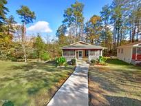 Charming house with walkway, porch, and wooded backdrop at 1122 E Ellerbee St, Durham, NC 27704
