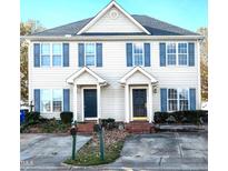 Two-story townhome with neutral siding, shutters, and a paved driveway at 2129 Ventana Ln, Raleigh, NC 27604