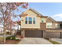 Front view of tan and brown brick townhome at 1203 Lotus Lilly Dr, Durham, NC 27713