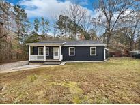 Dark-colored single story home with front porch and yard at 615 Wildaro Ct, Hillsborough, NC 27278