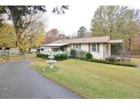 Ranch home with carport, landscaping, and a long driveway at 124 Jack Bennett Rd, Chapel Hill, NC 27517