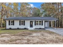 Newly renovated single story home with gray accents and a carport at 1518 Parks Village Rd, Zebulon, NC 27597