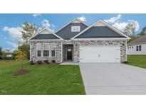 Attractive two-story home with stone and blue siding, a two-car garage, and a well-manicured lawn at 1680 Abberly Pl, Graham, NC 27253