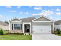 Gray one-story house with white garage door and landscaping at 2517 Trevana Way, Graham, NC 27253