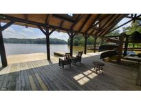 Relaxing boat dock with rocking chairs, canoes, and lake views at 171 Forest Bridge Rd, Youngsville, NC 27596