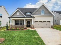 Two-story house with gray siding, brick accents, and a two-car garage at 1103 Nantucket Dr # 84, Mebane, NC 27302