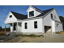 Two-story home with white siding, a covered porch, and a two-car garage at 1590 Nc 96 Hwy S, Franklinton, NC 27525