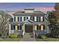 Two-story home with gray siding, stone accents, and a wrap-around porch at 3012 Bear Oak Ln, Cary, NC 27519