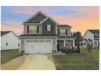 Two-story house with gray siding, double garage, and landscaping at 41 Red River Dr, Selma, NC 27576