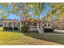 Single-story home with a covered porch and landscaped yard at 1619 Hunters Trl, Creedmoor, NC 27522