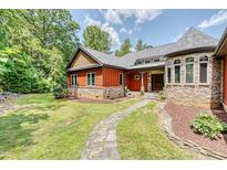 Stone and red siding two-story house with a walkway to the entrance at 3240 Hillcastle Trl, Chapel Hill, NC 27516