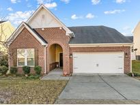 Brick home with a two-car garage and a landscaped lawn at 4148 White Kestrel Dr, Raleigh, NC 27616