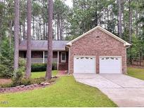 Brick ranch house with two-car garage and landscaped yard at 3064 Carolina Way, Sanford, NC 27332