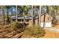Brick house with two-car garage and porch, nestled among tall pines at 3064 Carolina Way, Sanford, NC 27332