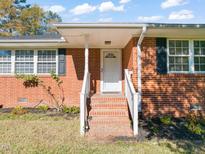 Brick ranch house with covered porch and a landscaped yard at 5813 Cheek Rd, Durham, NC 27704