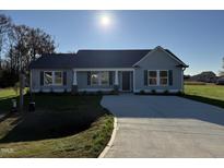 Gray house with a concrete driveway and landscaping at 198 Pate Landing Dr, Selma, NC 27576