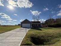 Gray exterior ranch home with attached garage and landscaped lawn at 45 New Bethel Ct, Lillington, NC 27546