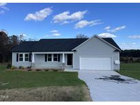 Newly constructed home with gray siding, a white garage door, and a well-maintained lawn at 50 Holly Grove Ln, Lillington, NC 27546