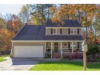 Two-story house with a gray exterior, white garage door, and landscaping at 1008 Oakgate Ct, Apex, NC 27502