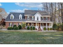 Brick two-story house with a large front porch and well-maintained lawn at 4027 Green Forest Ct, Rocky Mount, NC 27804