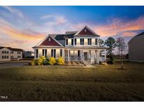 Two-story house with red accents, front porch, and landscaped yard at 46 Two Belles Ct, Angier, NC 27501