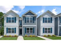 Three-unit townhome building with gray and white siding, landscaping, and walkways at 8658 Brixton Shay Dr, Raleigh, NC 27616