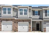 Modern townhome exterior with two-car garage and stone accents at 1812 Hinesley Dr, Durham, NC 27703