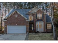 Two-story brick home with a large driveway and landscaped lawn at 3100 Lariat Ridge Dr, Wake Forest, NC 27587