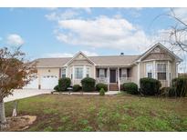 Beige house with two-car garage and landscaping at 7217 Blannie Farms Ln, Willow Springs, NC 27592