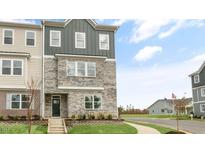 Three-story townhome with stone and siding exterior, steps leading to the entrance, and landscaping at 2243 Horton Park Drive, Apex, NC 27539