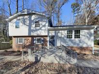 Two-story house with gray siding, brick accents, and a deck at 302 N Montreal Ct, Cary, NC 27511