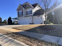 Two-story house with a three-car garage and landscaped yard at 374 W Falcon Ct, Clayton, NC 27520
