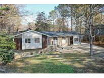 Brick ranch home with mature trees and landscaped yard at 5829 Sandstone Dr, Durham, NC 27713