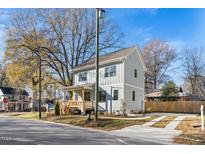 Two-story home with light gray siding, wooden porch, and a well-manicured lawn at 2501 Lednum St, Durham, NC 27704
