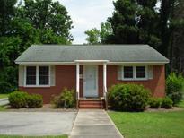 Brick ranch house with a landscaped lawn and walkway at 608 N Ellis Ave, Dunn, NC 28334
