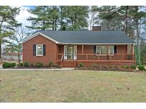 Brick ranch house with a large front porch and landscaped yard at 303 Forest Rd, Oxford, NC 27565