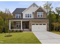 Two-story house with stone accents and a three-car garage at 3177 Armeria Dr, Apex, NC 27502