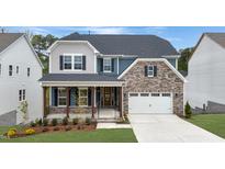 Two-story home with stone and shingle accents, a front porch, and a two-car garage at 3185 Armeria Dr, Apex, NC 27502