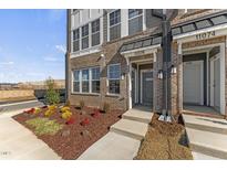 Brick front exterior of townhome with landscaped garden at 1235 Shaw View Alley # 201, Raleigh, NC 27601