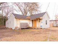 Beige house with a gray roof, small porch, and a partially fenced yard at 234 W Raleigh Blvd, Rocky Mount, NC 27803