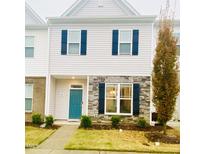 Two-story townhome with gray siding, teal door, and stone accents at 242 Liam St, Clayton, NC 27520