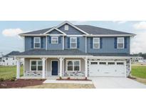 Two-story house with blue siding, stone accents, and a covered porch at 68 Northwood Dr, Fuquay Varina, NC 27526