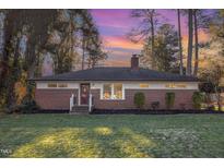 Brick ranch house with a well-manicured lawn at 219 W Franklin St, Zebulon, NC 27597